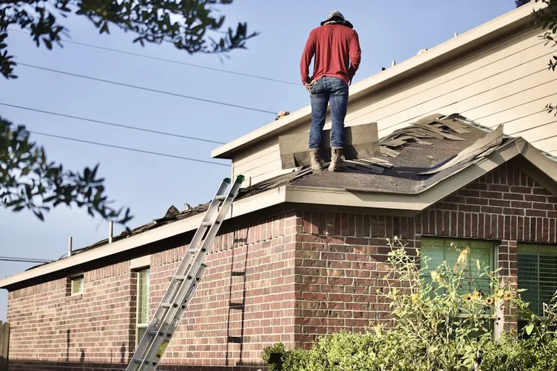 Professional roofer working on a residential roof in North Benton